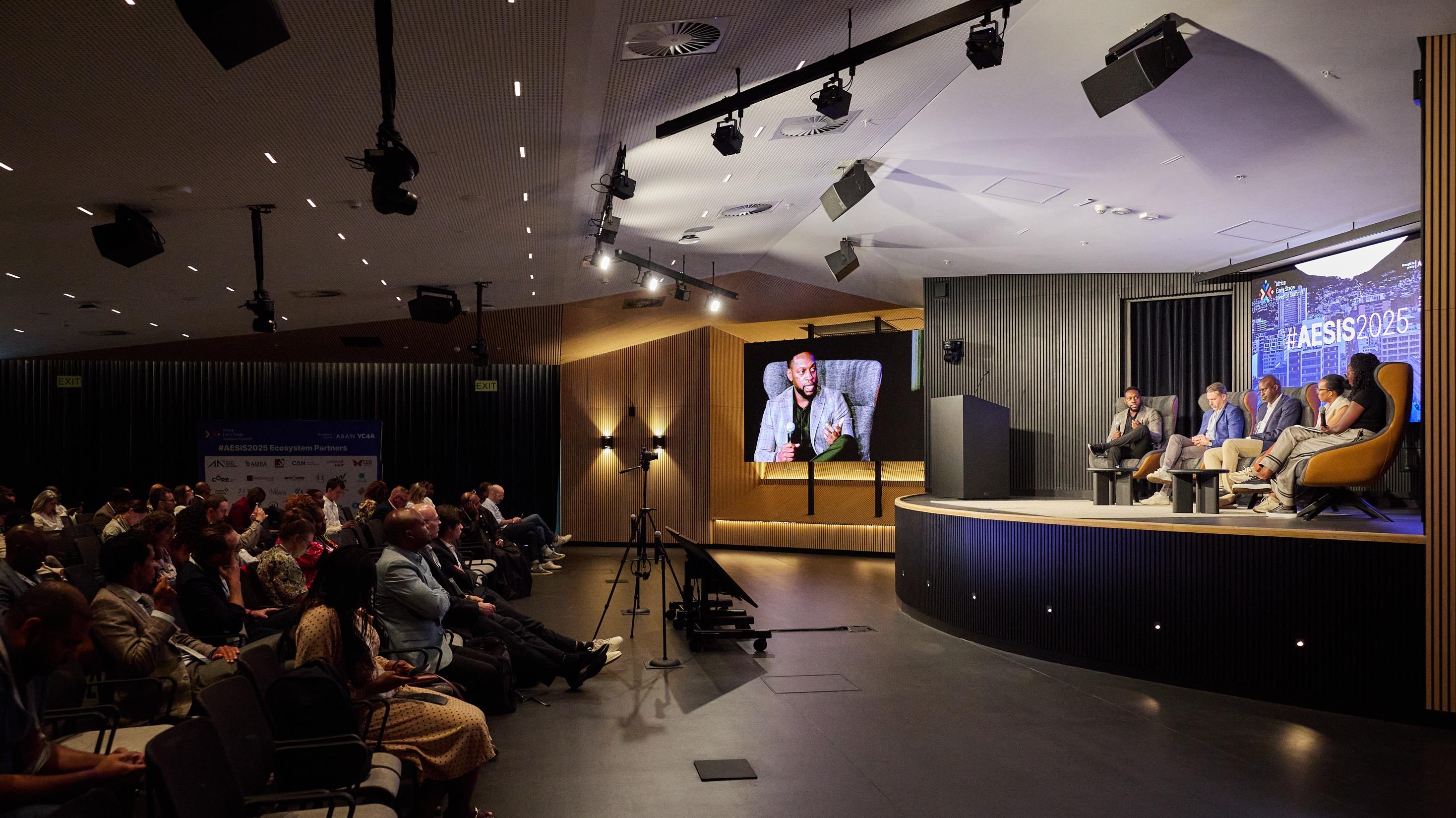 Investors seated in a summit hall during a panel session in Cape Town