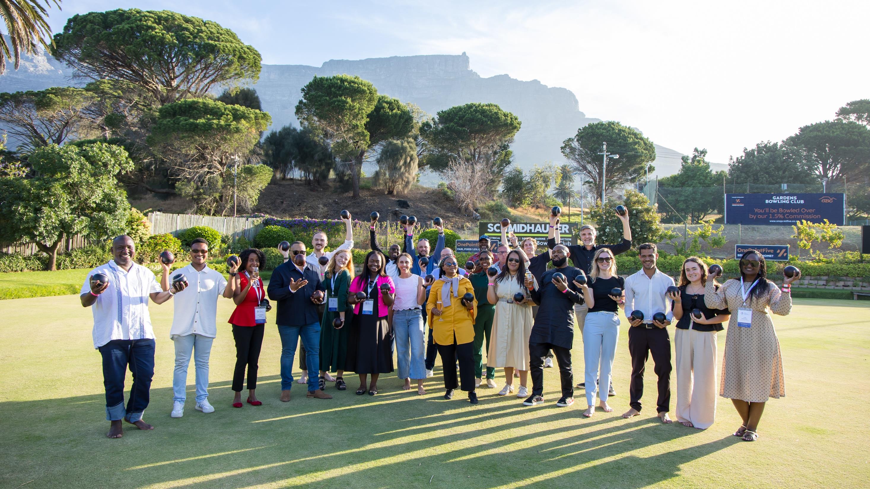 Members at an outdoor investor gathering in Cape Town beneath Table Mountain